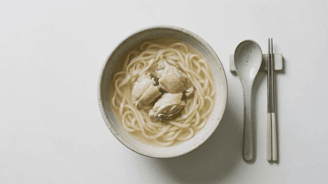 Bowl of chicken kalguksu placed with chopsticks.