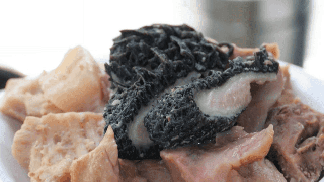 흰 접시에 담긴 소 내장 수육