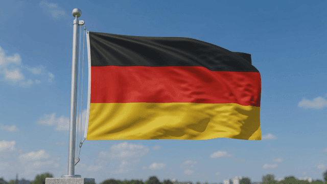 German flag waving against a blue sky