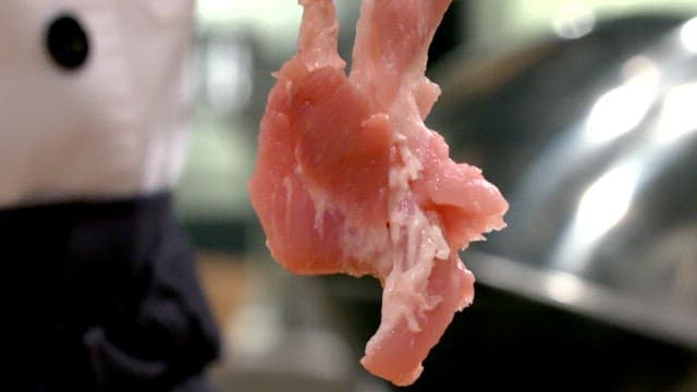 주방에서 손질된 생 돼지갈비를 들고 있는 요리사