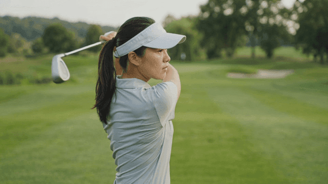 Woman playing golf on clear day.