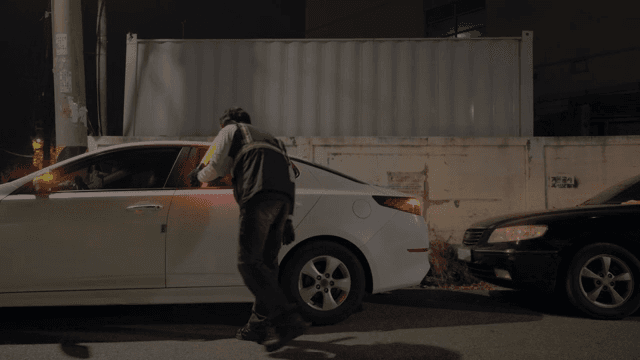 주차된 차를 점검하는 순찰관