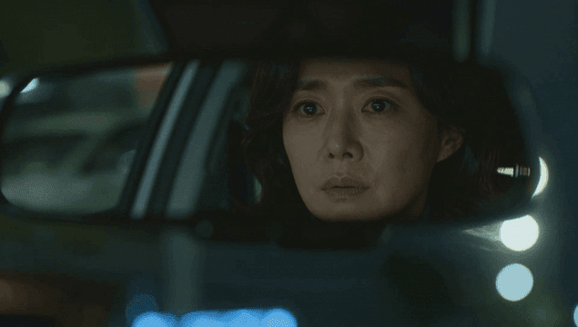 밤에 차 안 집중한 여성을 비추는 룸미러