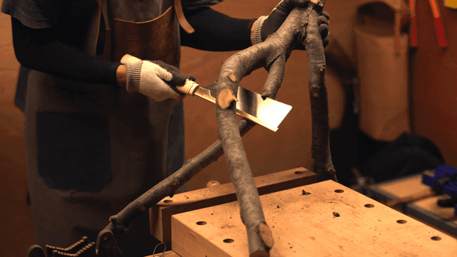 실내에서 나무 가지를 자르는 장인