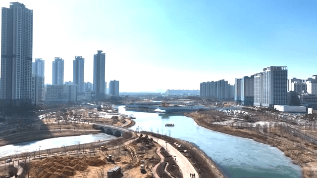Modern city skyline with a river and park