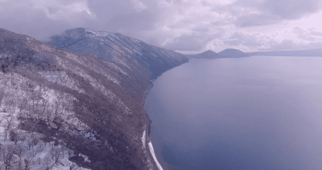 Snow-covered mountains by a calm sea