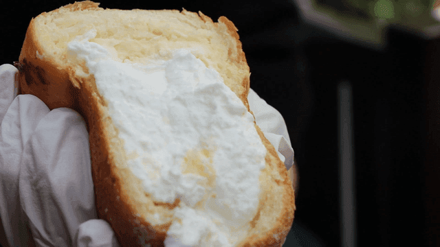 장갑 낀 손에 들린 크림빵