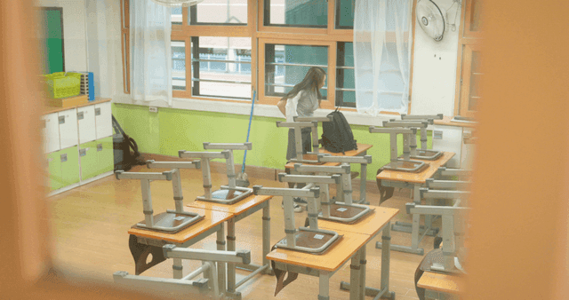 Student preparing to leave school in an empty classroom