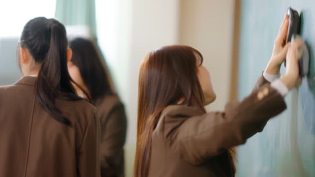 Student cleaning a classroom board