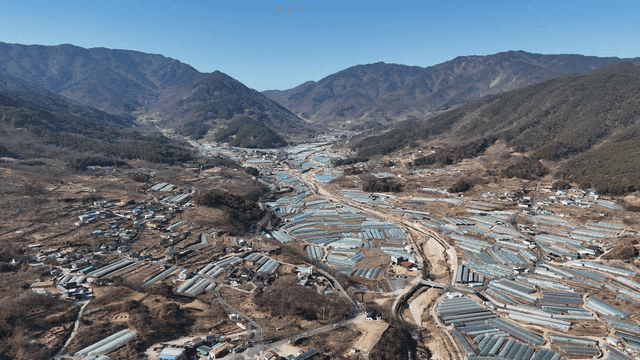 Rural village with vinyl greenhouse in valley