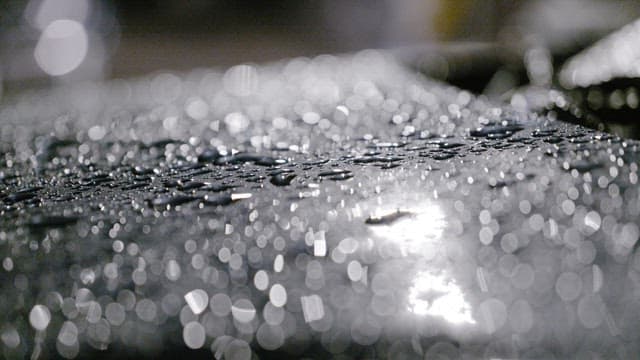 밤에 매끄러운 표면에 반짝이는 빗방울들