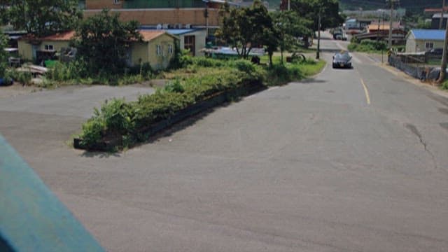 맑은 날 시골 건물을 지나는 차