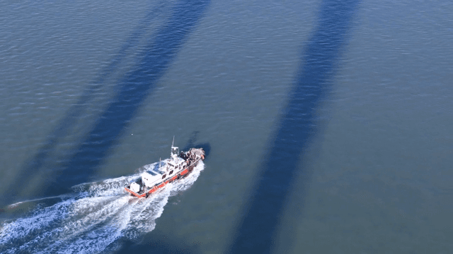 Boat sailing on a sea with shadows