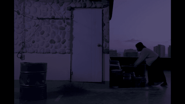 해질녘 옥상에서 양동이를 옮기는 여성