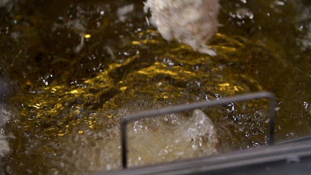 뜨거운 기름에 빵가루를 묻힌 돈가스를 튀기기