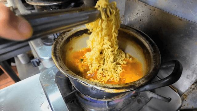 Cooking ramyeon in a pot on a gas stove