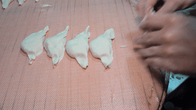 쟁반 위에서 만두를 빠르게 접는 손