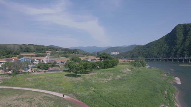 푸른 산과 강이 보이는 평화로운 농촌 마을