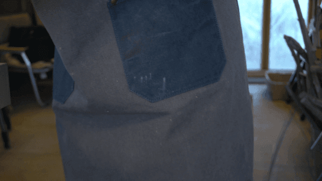 작업실에서 나무 조각을 들고 있는 장인