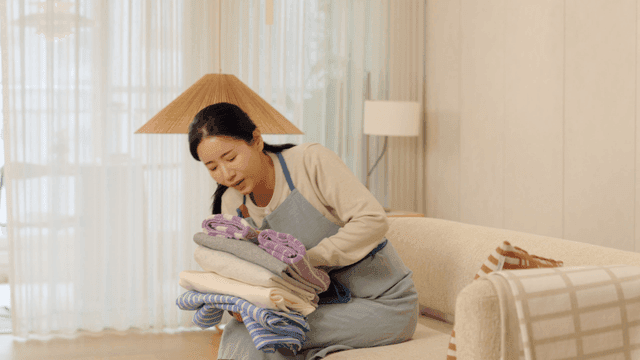 Woman feels back pain while carrying laundry