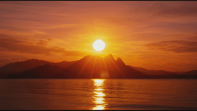 Sun rising behind mountain range