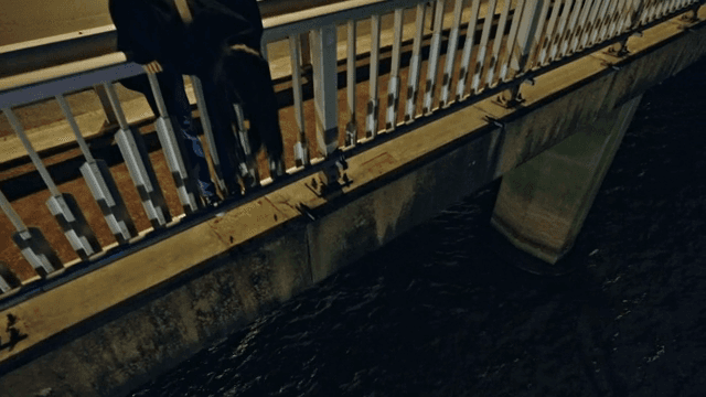 밤에 다리 위에 기대어 있는 사람