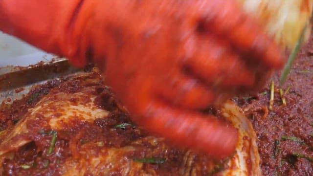 배추에 고추 양념을 넣어 김치를 만드는 모습