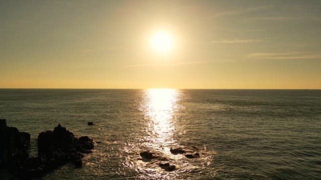 바위가 있는 고요한 바다의 일몰