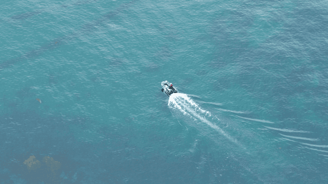 맑은 바다 위를 빠르게 달리는 작은 보트