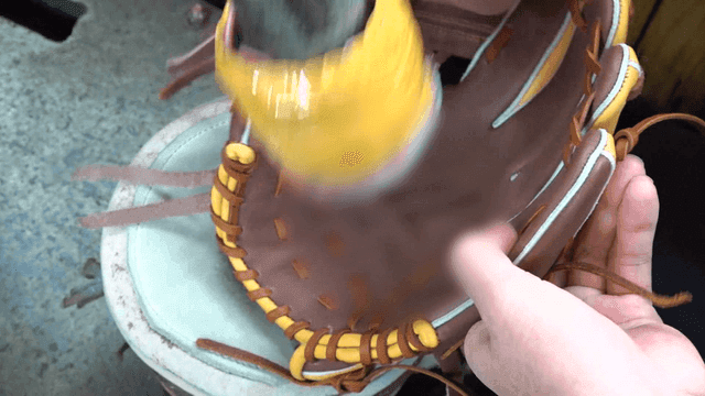 Craftsman polishing baseball glove with machine