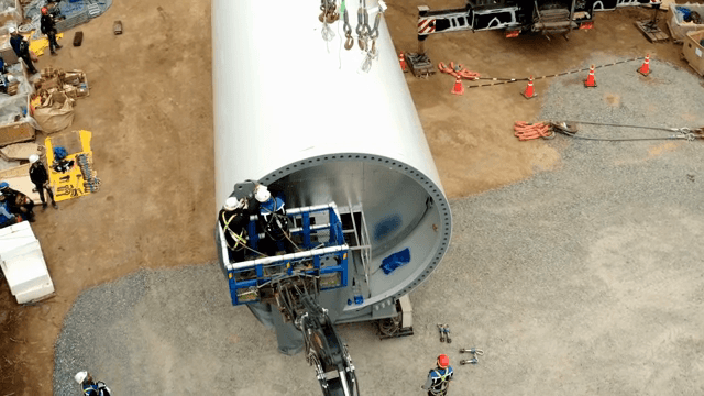 작업자들이 대형 풍력 터빈을 조립하는 모습