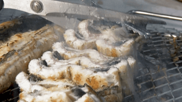 바비큐 그릴에서 가위로 자르는 장어구이