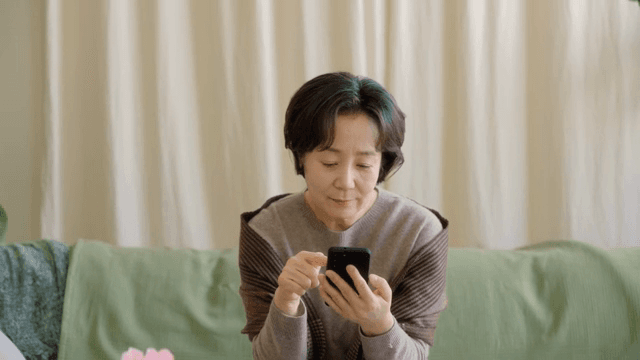 소파에서 스마트폰을 사용하는 여성