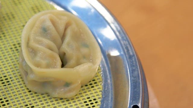 Steamed dumplings plated in a steamer on the table