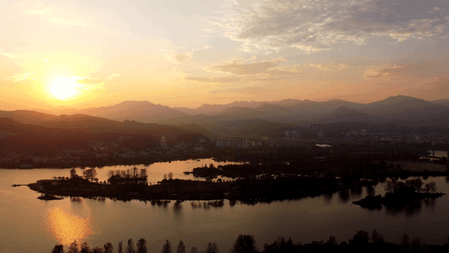 Sunset over a serene lake and distant city