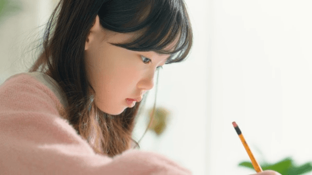 Child concentrating on homework indoors