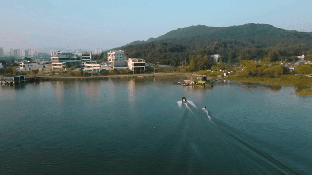 Boats speeding across lake, water skiing