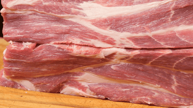 나무 도마 위에 쌓인 생 돼지고기