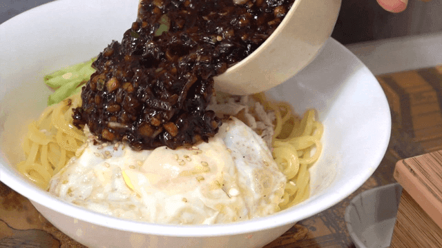 Jajangmyeon topped with fried egg and cucumber