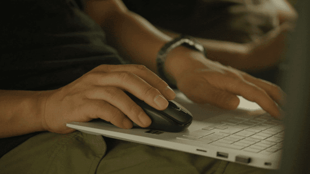 Person using a laptop with a mouse