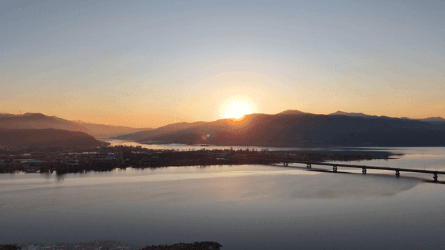 Sunset over a tranquil river and mountains