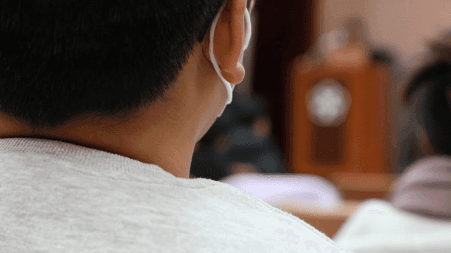 Back of student listening intently in class