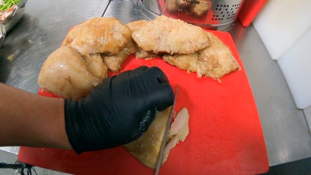 Slicing Roasted Chicken in a Kitchen of Restaurant