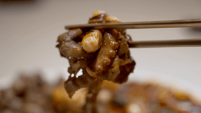 Chopsticks holding spicy stir-fried octopus