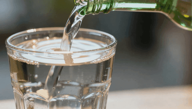 Glass being filled with clear soju