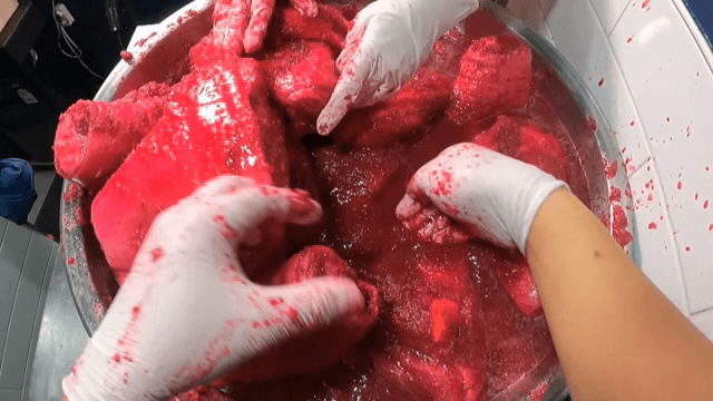 돼지 다리에 비트를 갈은 소스를 버무리는 모습