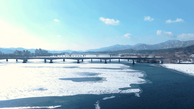 다리와 산이 있는 얼어붙은 강