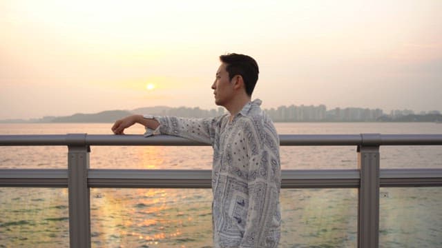 Man looking at the sea at sunset