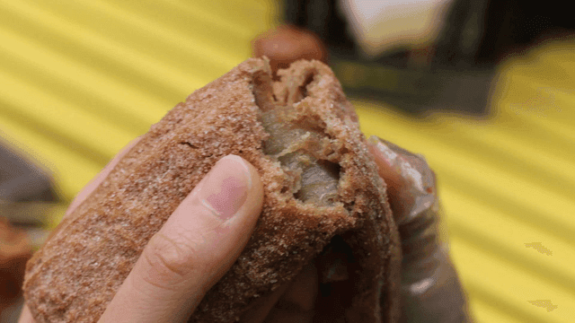 Hands breaking a churro with filling