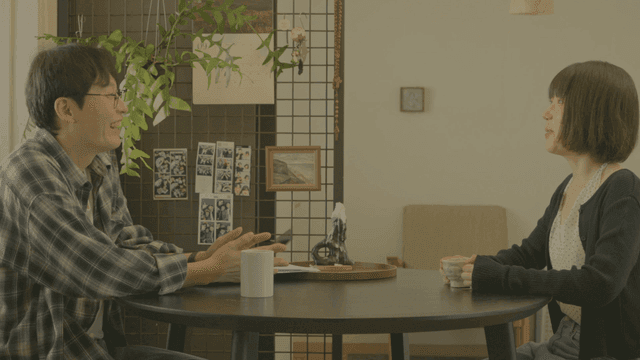 집 식탁에 앉아 대화하는 두 사람